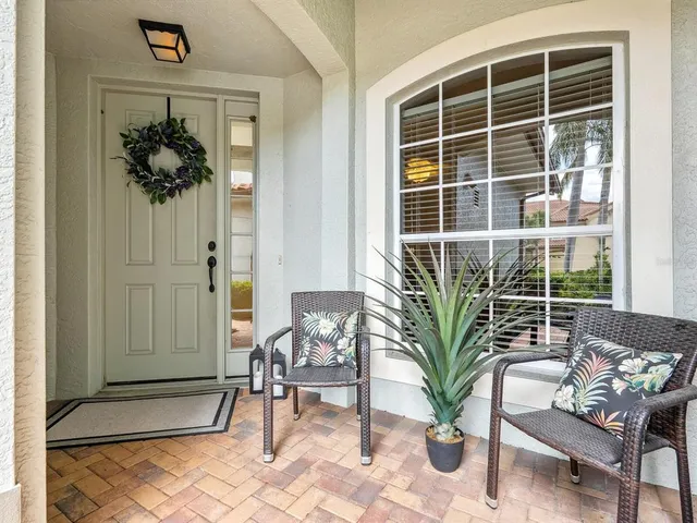 a view of a porch with chairs and potted plant