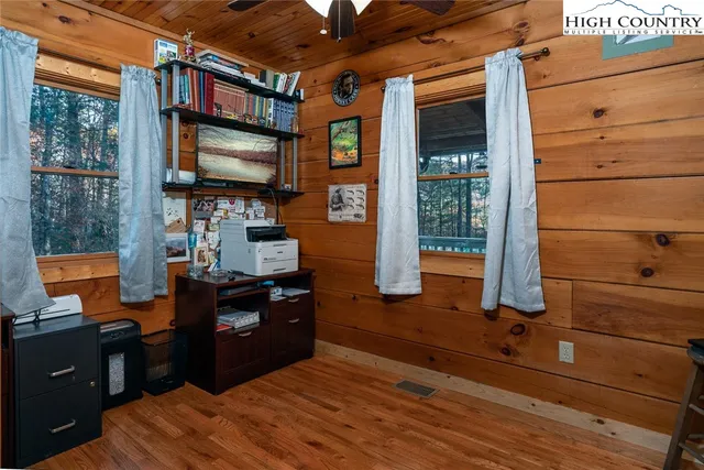 a living room with hard wood floors and a flat screen tv