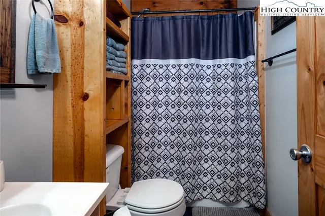 a bathroom with a toilet and a shower curtain