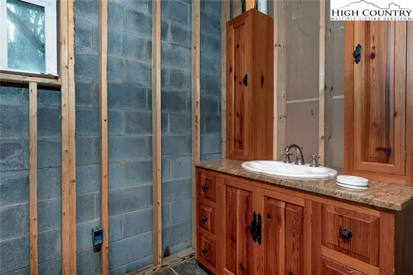 a bathroom with a granite countertop sink and a mirror
