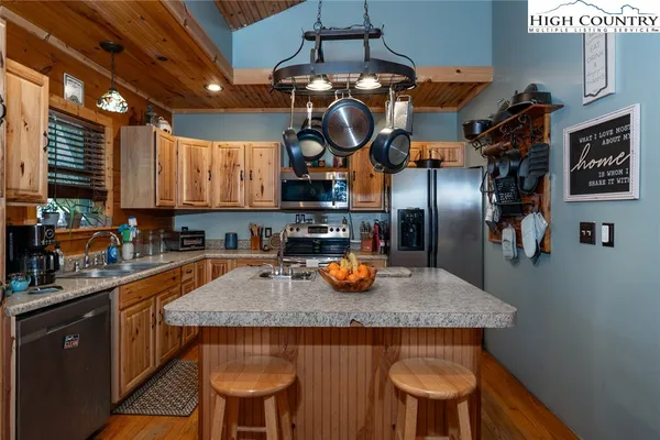 a kitchen with a sink a stove and chairs