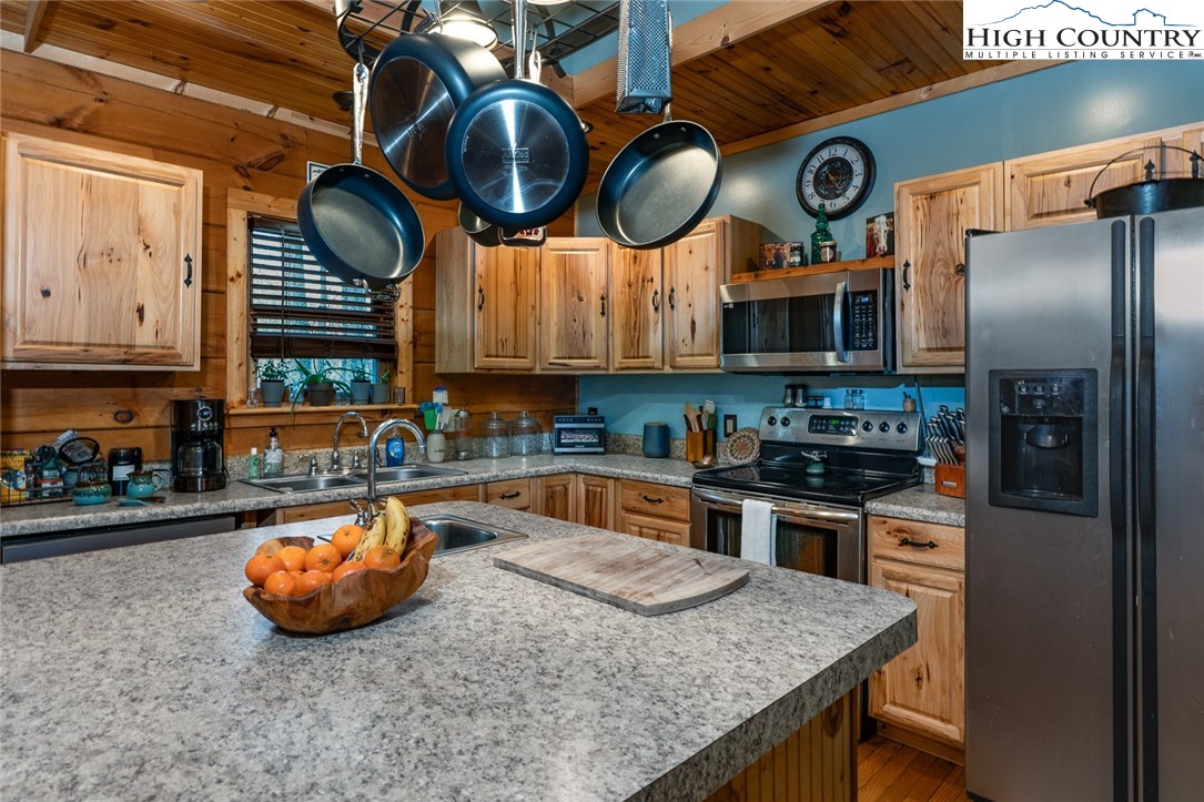 2417 Russell Norris Road Elk Park, NC 28622 - Photo 6 of 22 a kitchen with stainless steel appliances granite countertop a sink a stove and a wooden cabinets