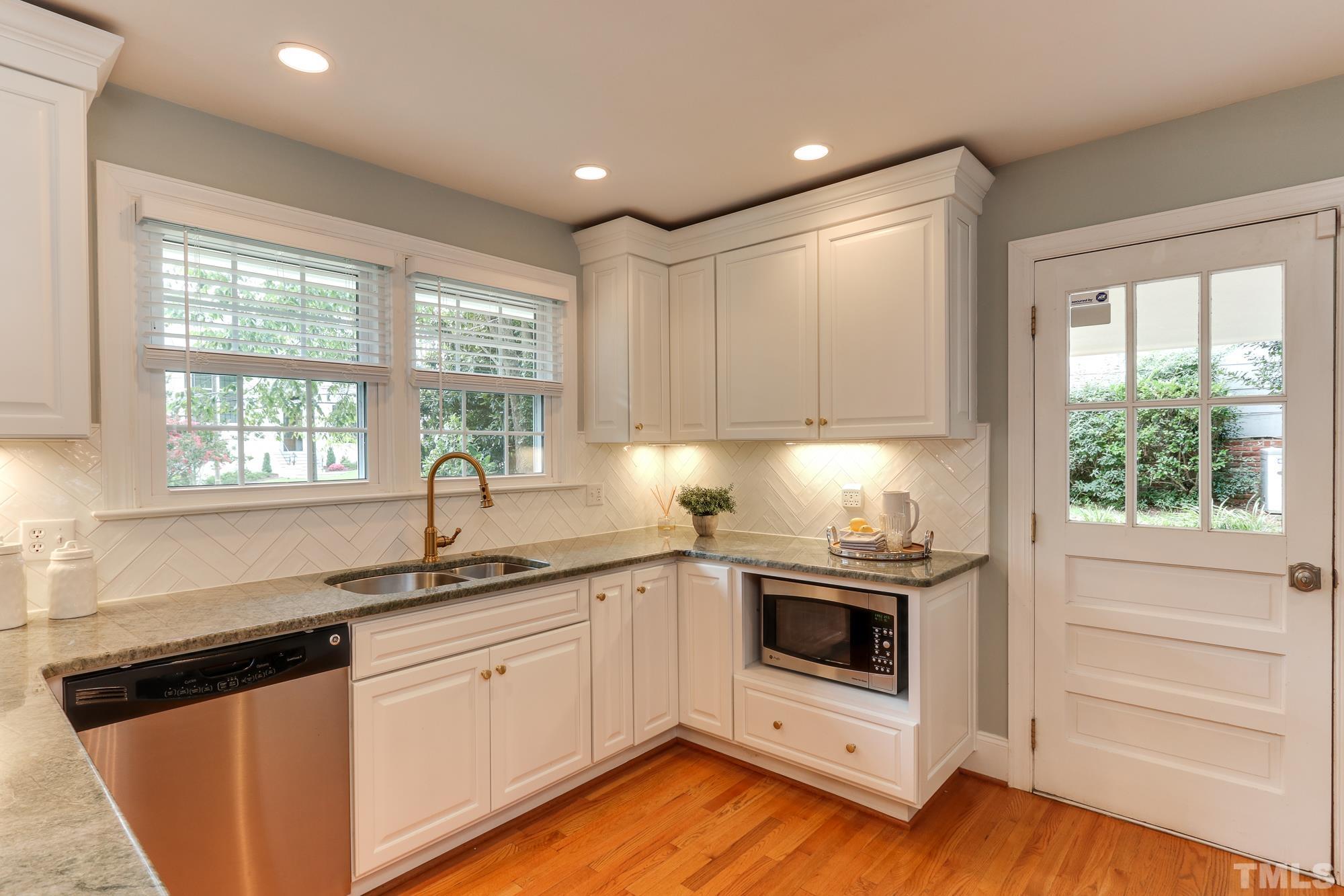 4804 Rampart Street Raleigh, NC 27609 - Photo 12 of 27 a kitchen with a sink stove and cabinets