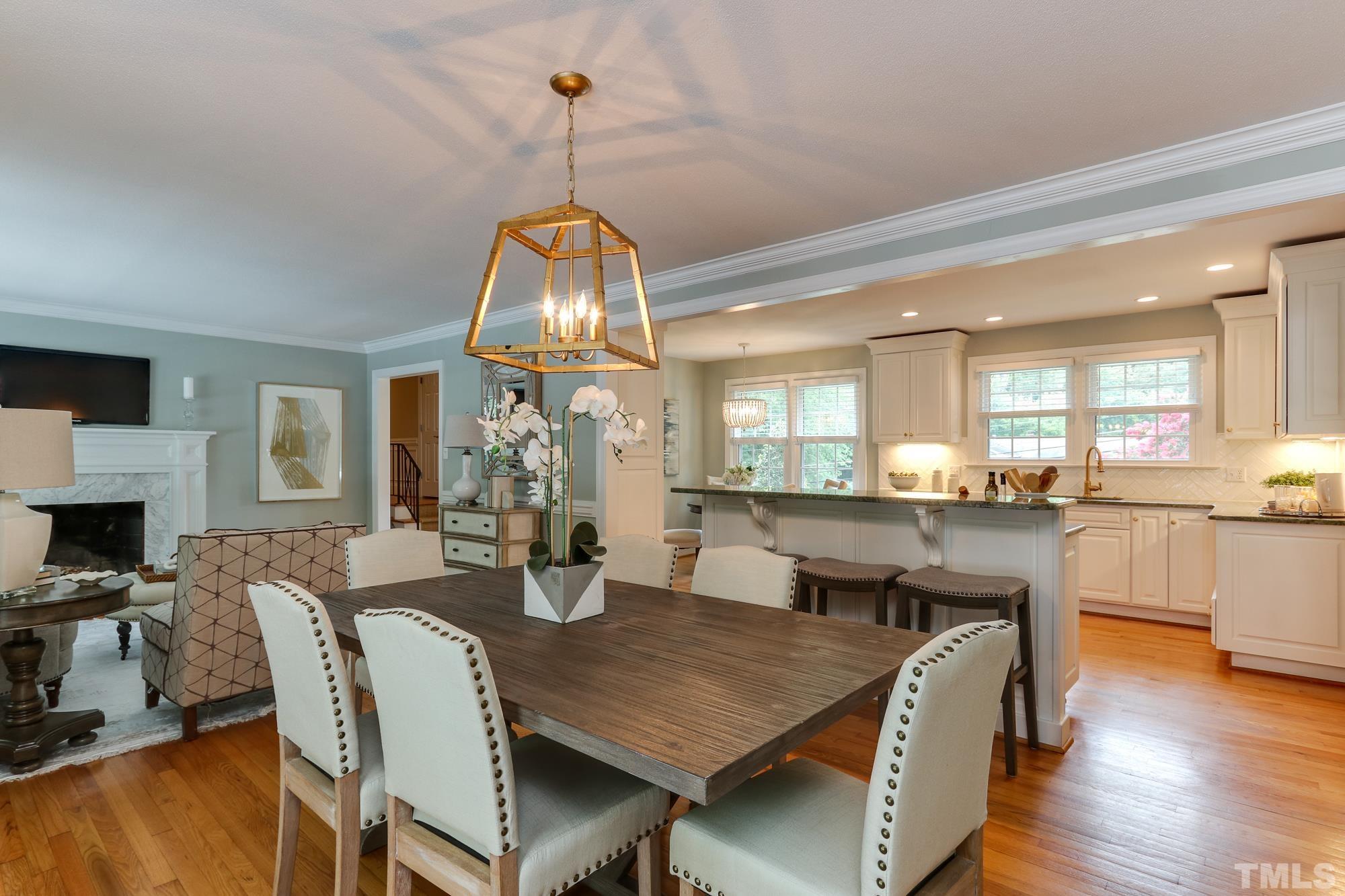 4804 Rampart Street Raleigh, NC 27609 - Photo 8 of 27 a view of a dining room with furniture a chandelier and wooden floor