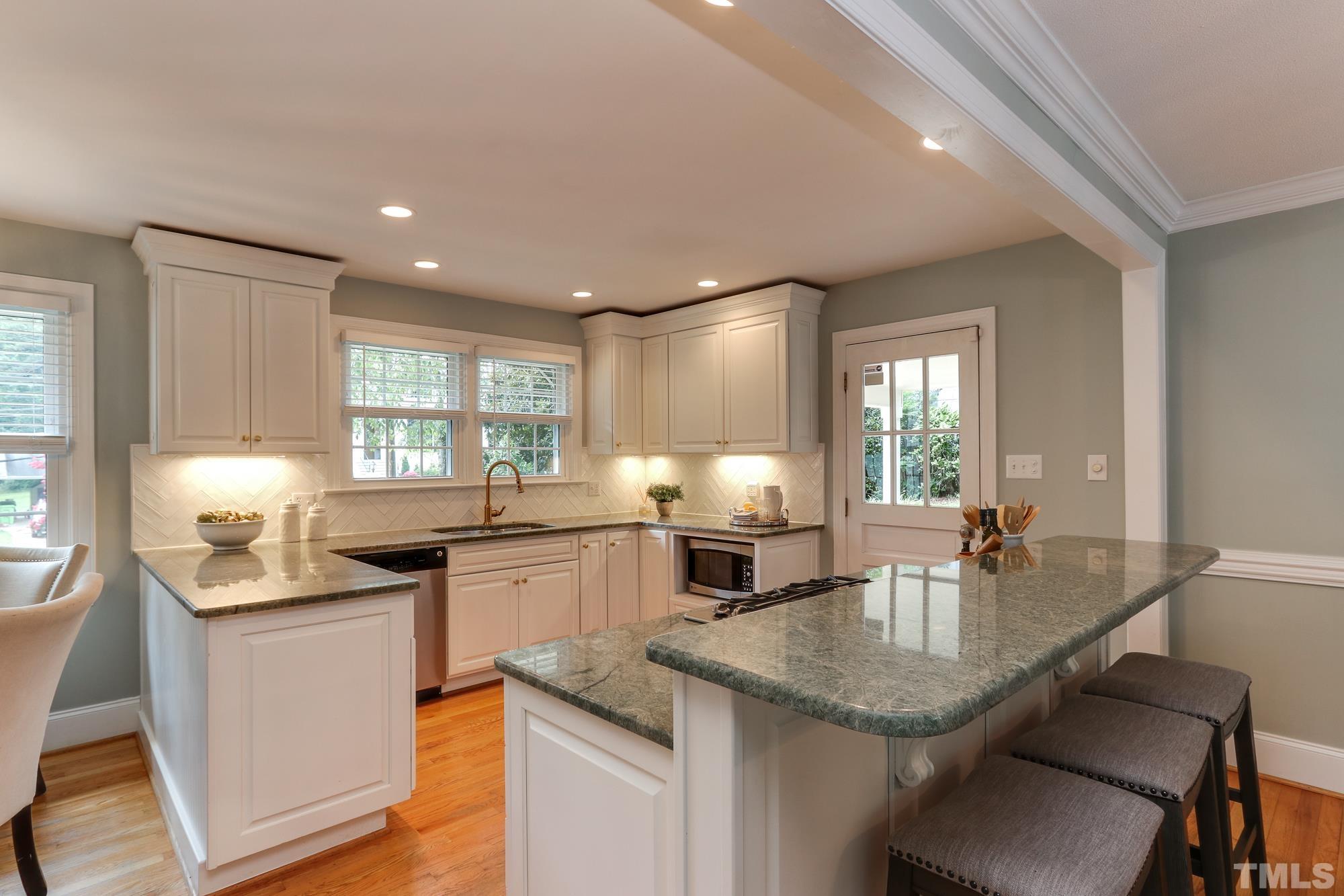 4804 Rampart Street Raleigh, NC 27609 - Photo 9 of 27 a kitchen with granite countertop kitchen island stainless steel appliances a sink and stove