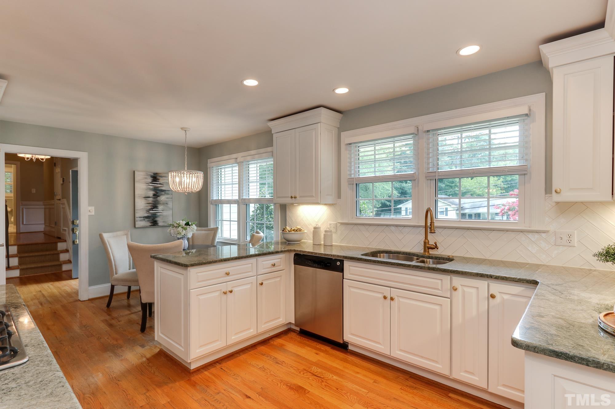 4804 Rampart Street Raleigh, NC 27609 - Photo 10 of 27 a kitchen with granite countertop kitchen island white cabinets and white appliances