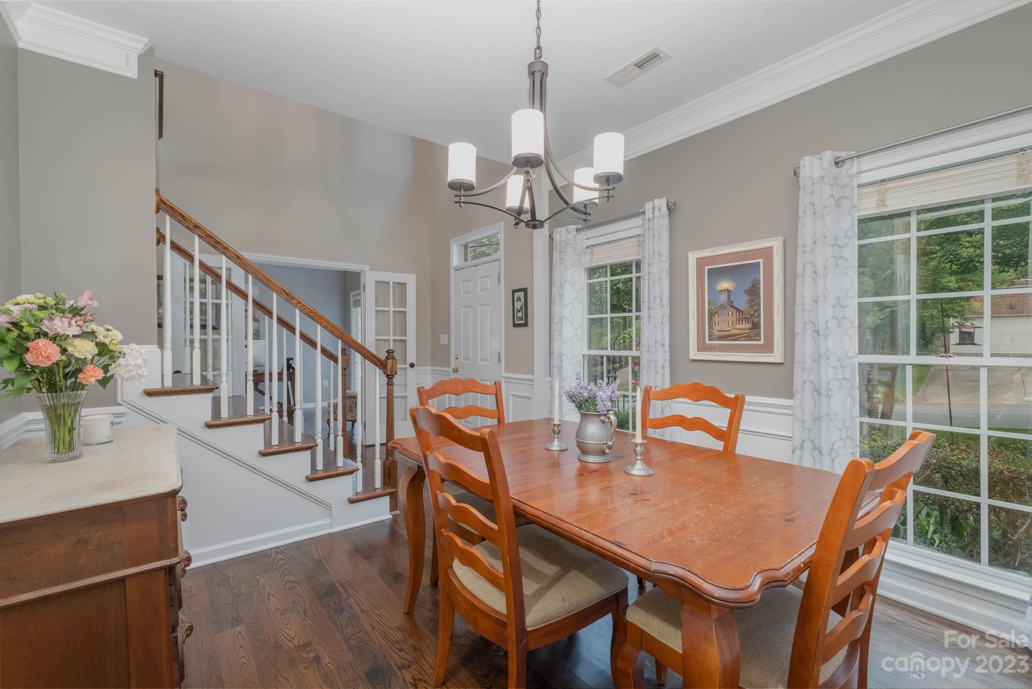 19739 Valiant Way Cornelius, NC 28031 - Photo 6 of 48 a dining room with wooden floor a chandelier a wooden table and chairs