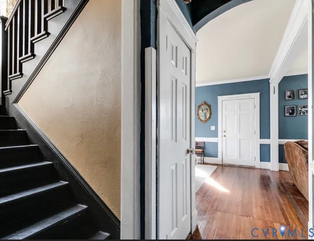 a view of a hallway with wooden floor and staircase
