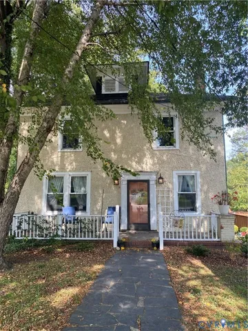 a front view of a house with a garden and yard