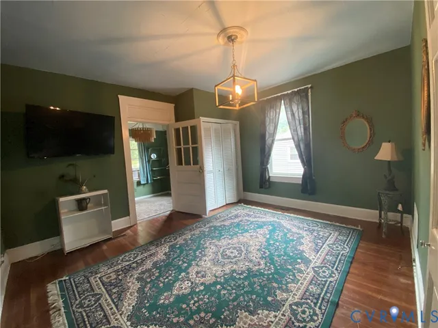 a view of a hallway with wooden floor and a chandelier