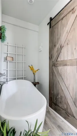 a bed sitting in a bathroom next to a wooden cabinet