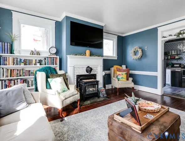 a living room with furniture a flat screen tv and a fireplace