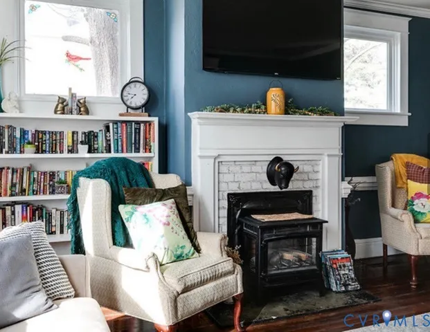 a living room with furniture a fireplace and a book shelf