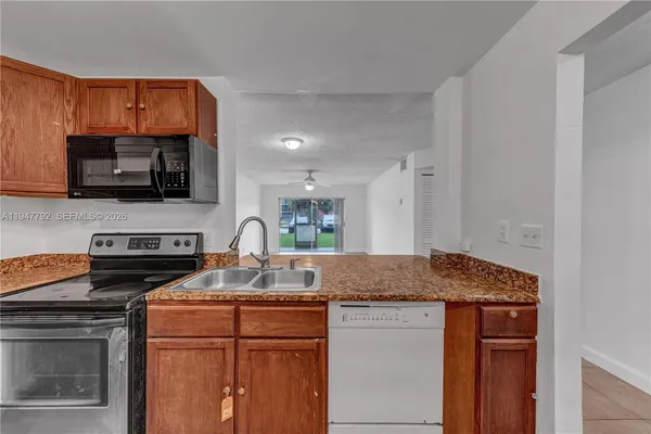 a kitchen with granite countertop a stove and a microwave