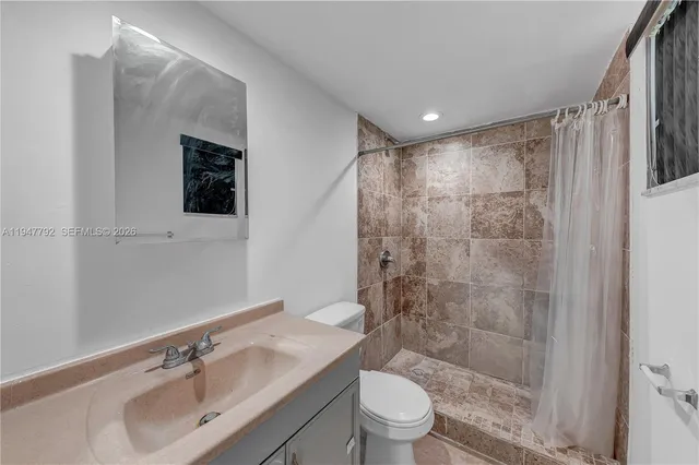 a bathroom with a sink toilet a mirror and shower