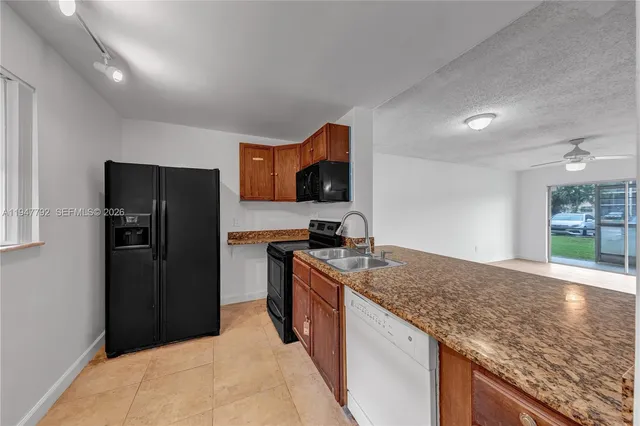 a kitchen with granite countertop a refrigerator and a sink