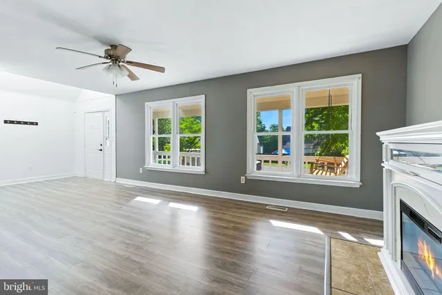 a view of an empty room with window and wooden floor