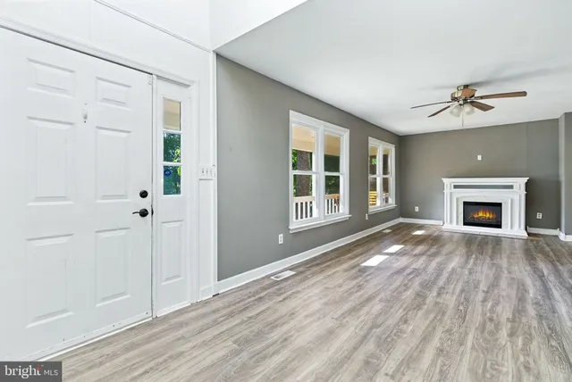 a view of empty room with wooden floor and fireplace