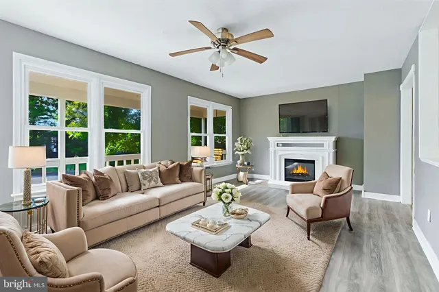 a living room with furniture a fireplace and a flat screen tv