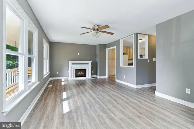 wooden floor fireplace and windows in an empty room