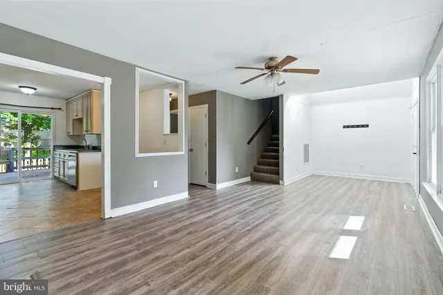 a view of a livingroom with wooden floor and a ceiling fan