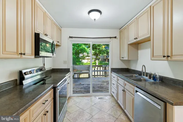 a kitchen with granite countertop a sink stove and cabinets