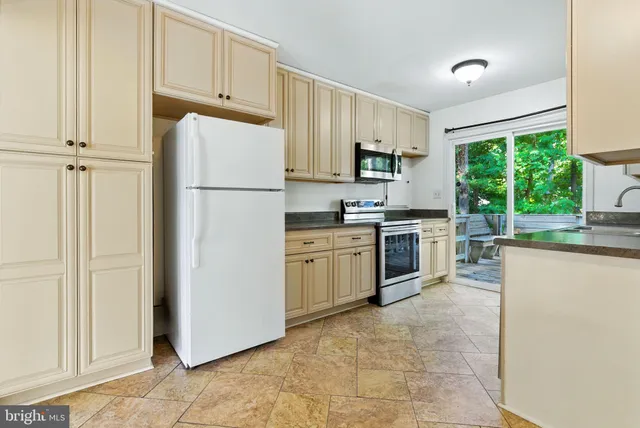 a kitchen with white cabinets and white appliances