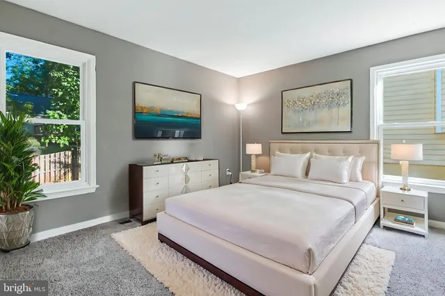 a bedroom with a bed a rug and a window