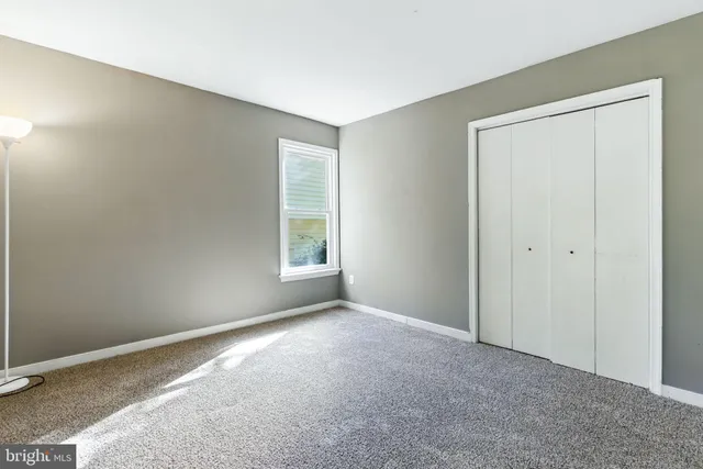 an empty room with windows and closet
