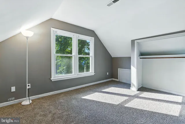 an empty room with windows and closet