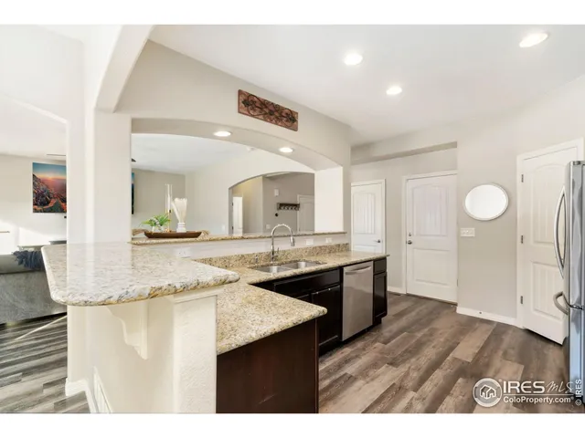 a large kitchen with stainless steel appliances granite countertop a stove a sink dishwasher and a microwave oven with cabinets