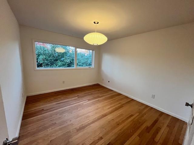 3322 Ocotea Street Raleigh, NC 27607 - Photo 27 of 31 an empty room with wooden floor and windows