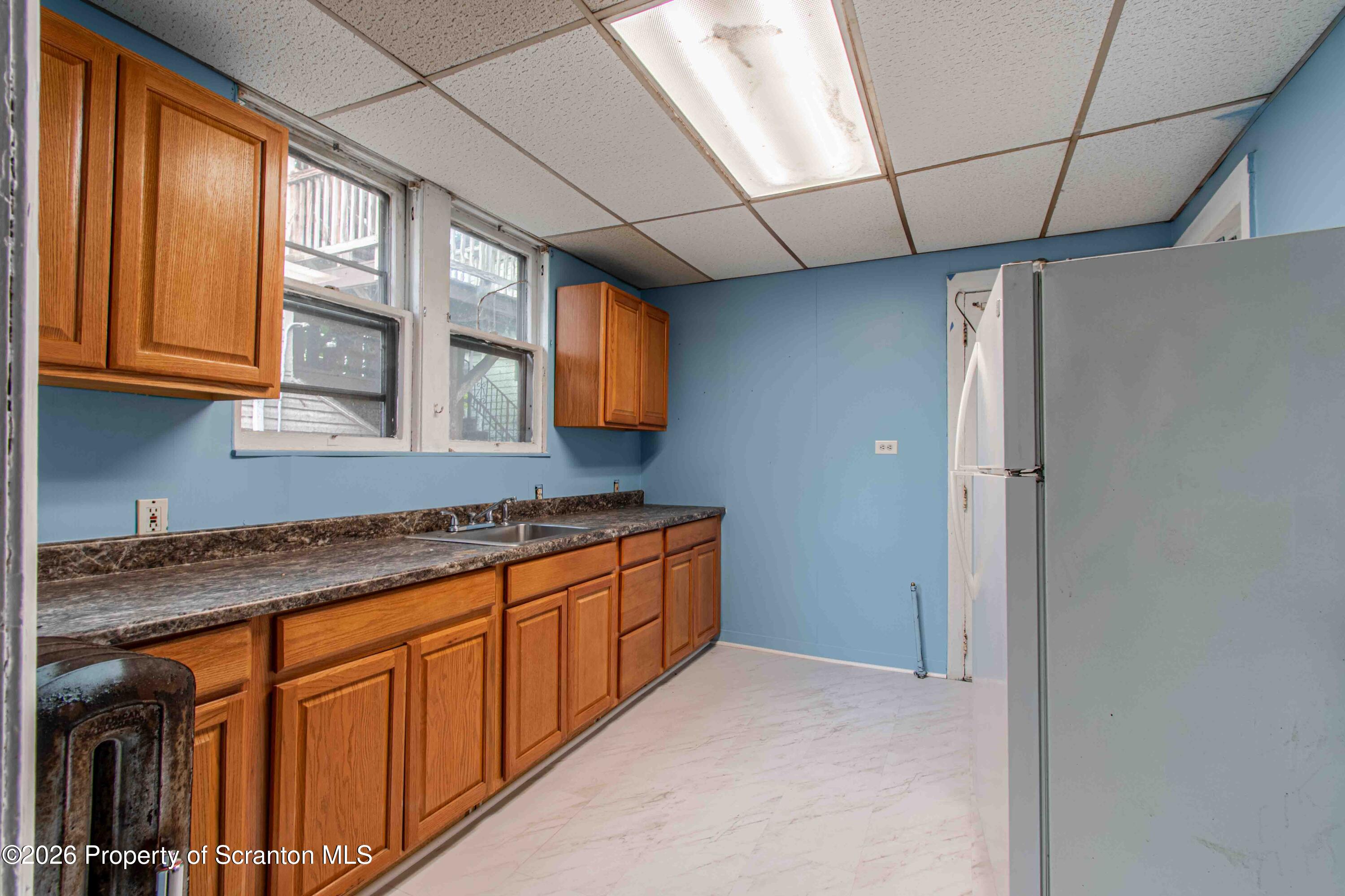 844 Monroe Avenue, Unit 844 Scranton, PA 18510 - Photo 8 of 15 a kitchen with stainless steel appliances granite countertop a sink and cabinets with wooden floor