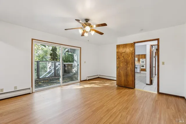a view of an empty room with fireplace and a window