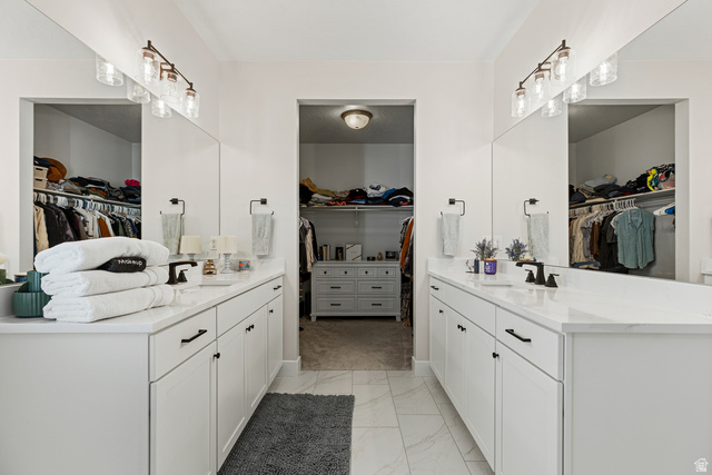 839 Walker Way St. George, UT 84770 - Photo 13 of 32 Dual vanity bathroom featuring matte black fixtures, white cabinetry, integrated sinks, and individual mirrored walls with multi-bulb light fixtures