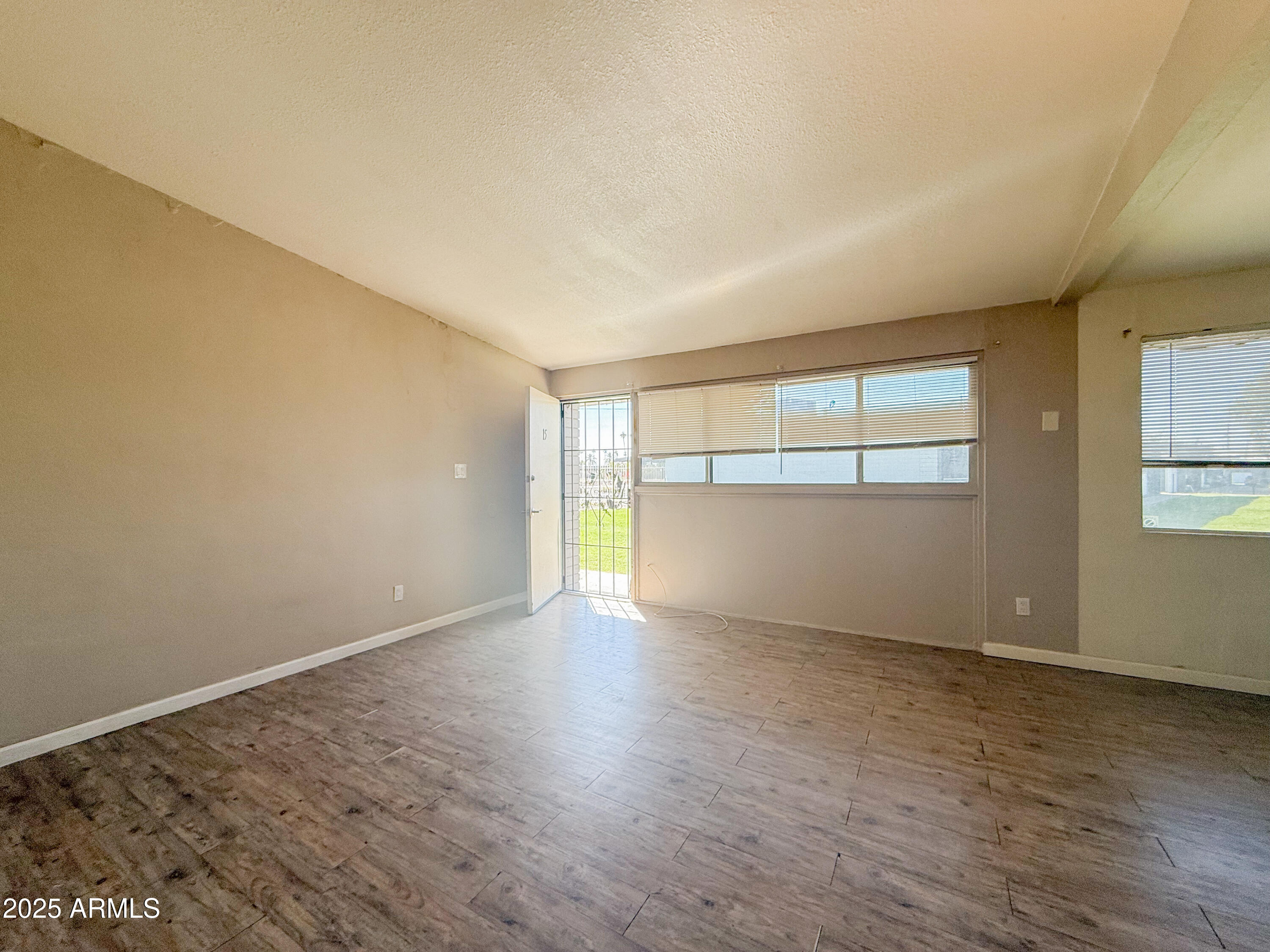 2123 West Devonshire Avenue, Unit 15 Phoenix, AZ 85015 - Photo 9 of 14 an empty room with wooden floor and windows
