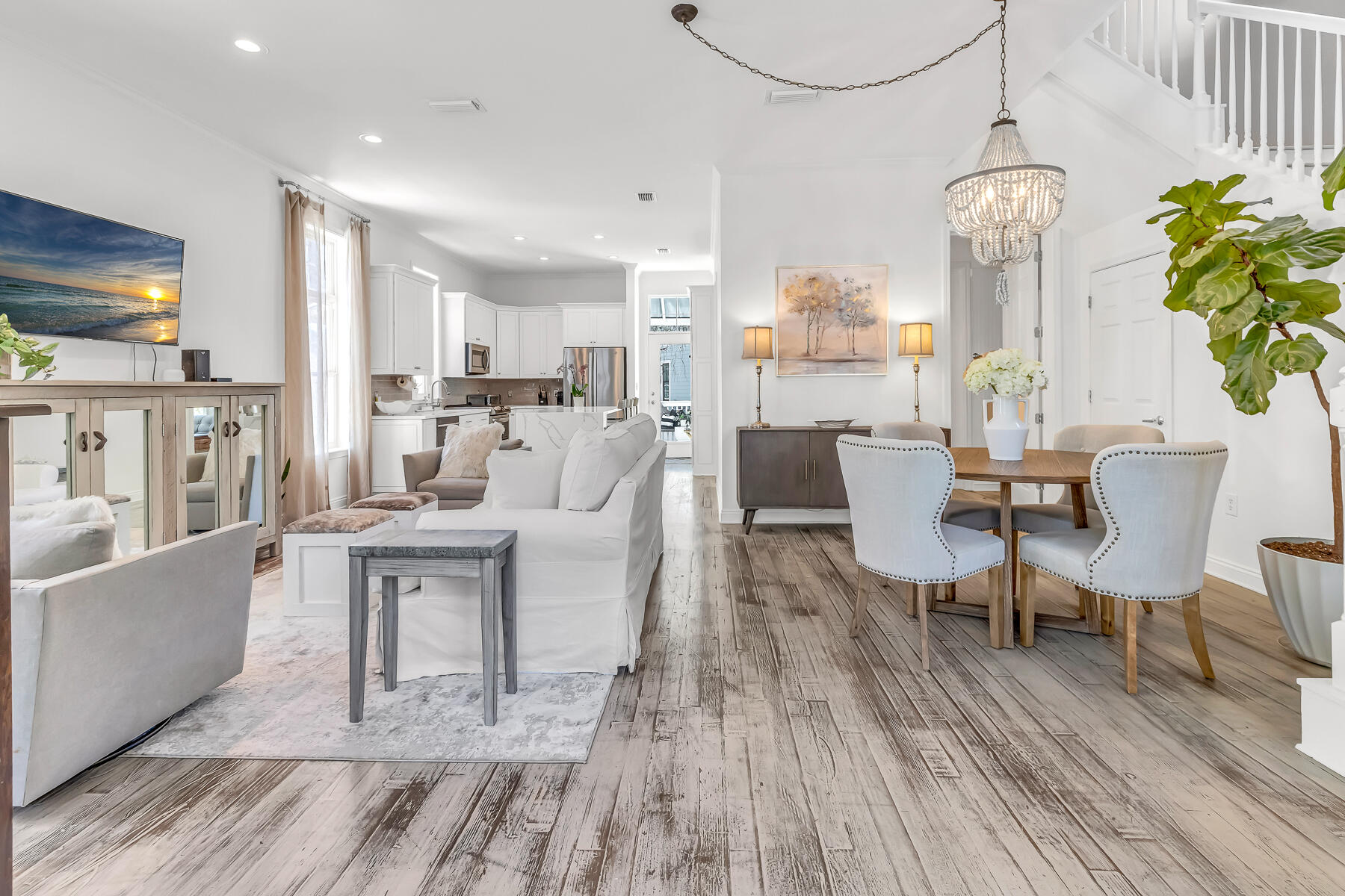 a living room with furniture a chandelier and wooden floor