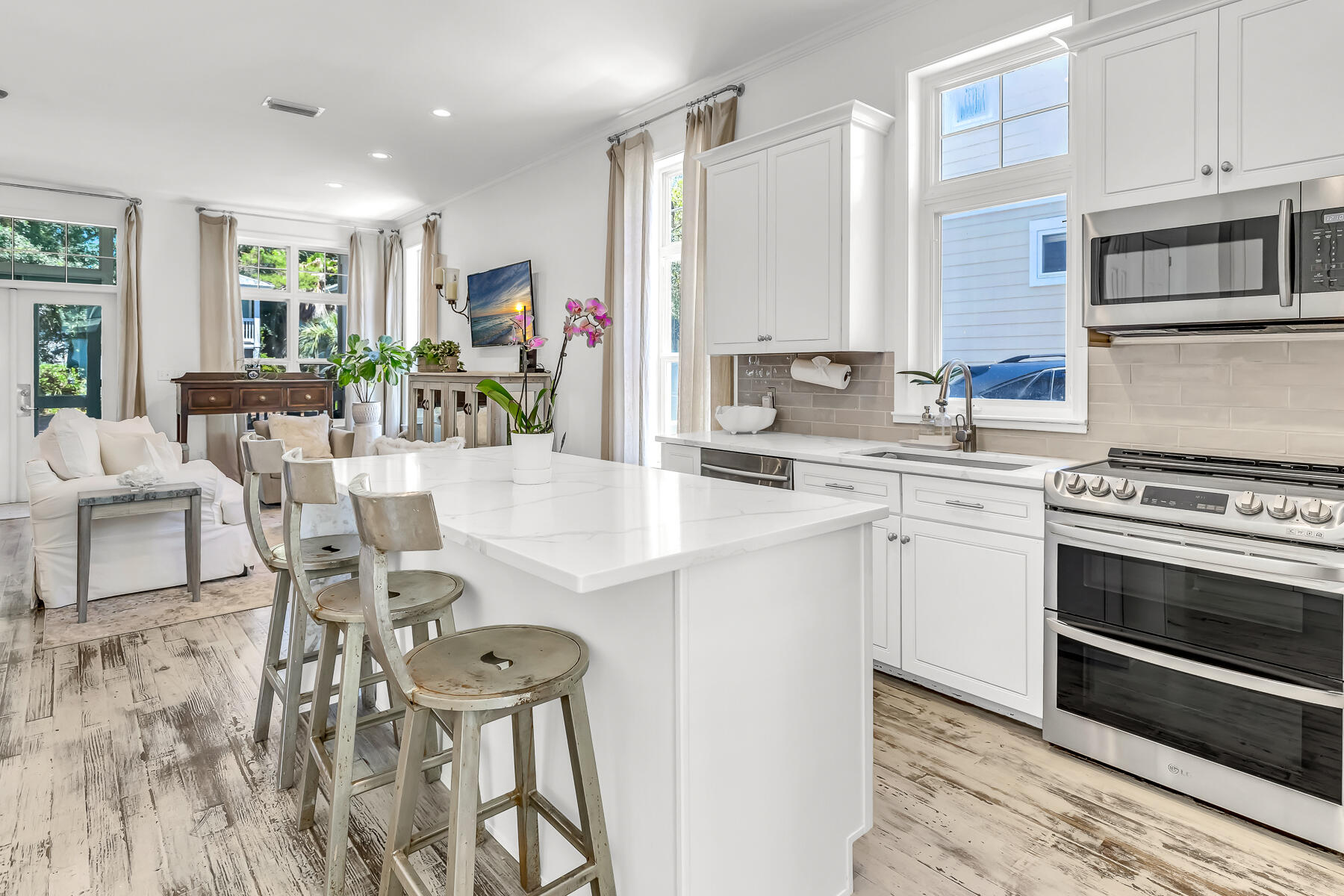 79 Redfish Circle Santa Rosa Beach, FL 32459 - Photo 6 of 33 a kitchen with stainless steel appliances granite countertop a stove top oven a sink dishwasher a dining table and chairs with wooden floor