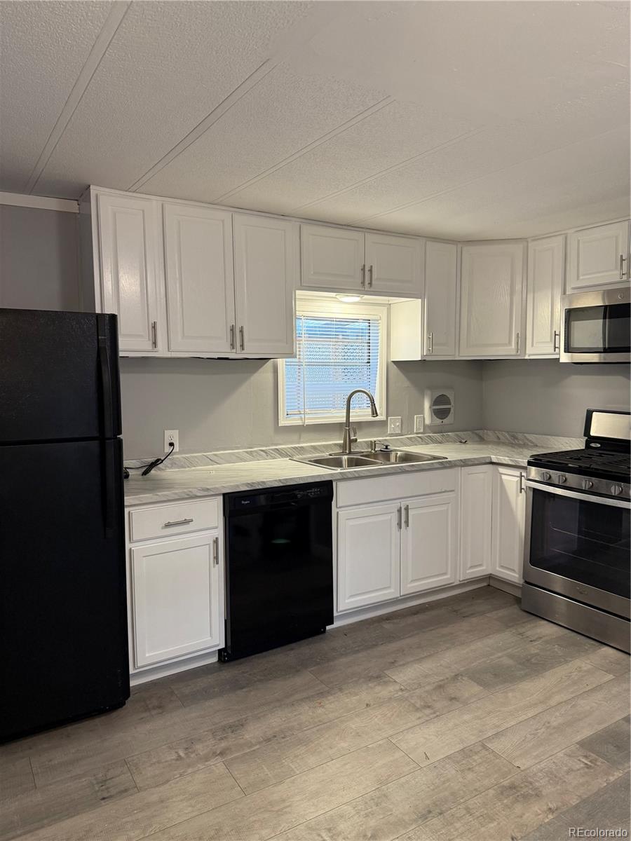 17190 Mt Vernon Road, Unit 176 Golden, CO 80401 - Photo 7 of 39 a kitchen with a refrigerator stove top oven and cabinets