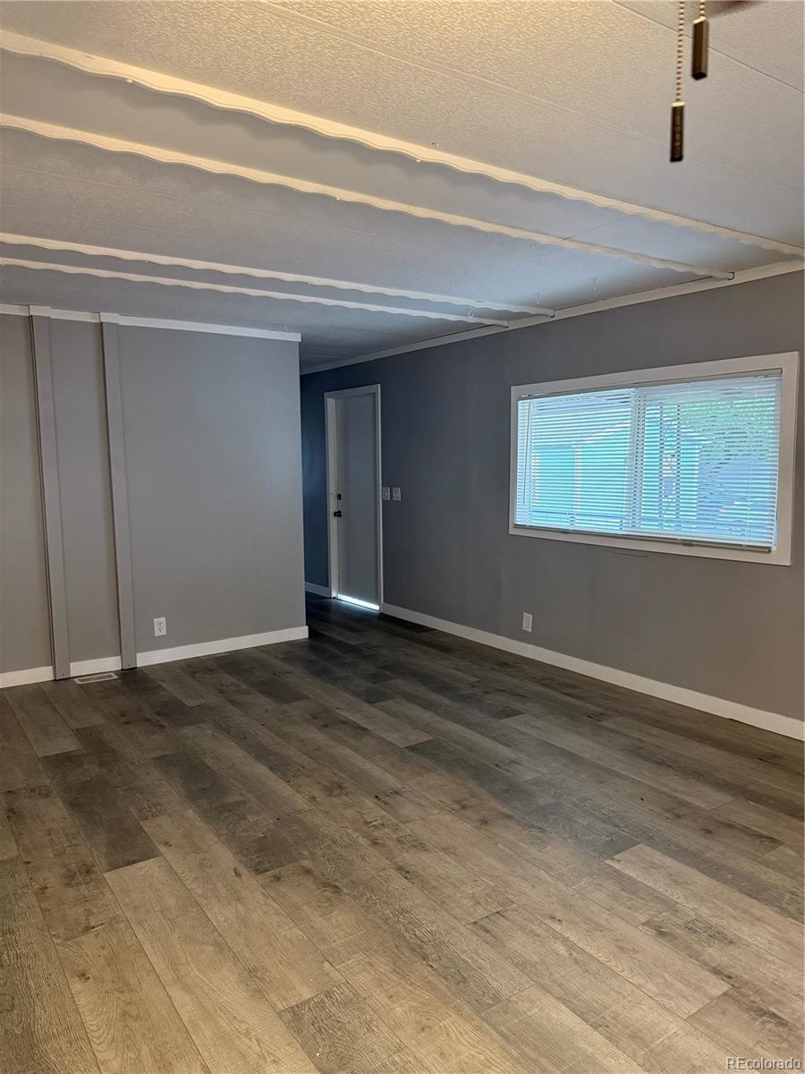 17190 Mt Vernon Road, Unit 176 Golden, CO 80401 - Photo 8 of 39 a view of an empty room with wooden floor and a window