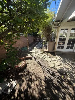 a view of a backyard with table and chairs and wooden fence