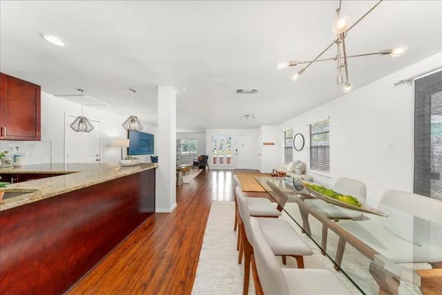 a kitchen with a dining table chairs stainless steel appliances and cabinets