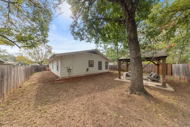 a view of a house with a yard and tree