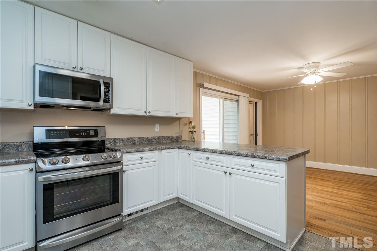 1234 Cross Link Road Raleigh, NC 27610 - Photo 11 of 26 a kitchen with granite countertop a stove top oven microwave and cabinets