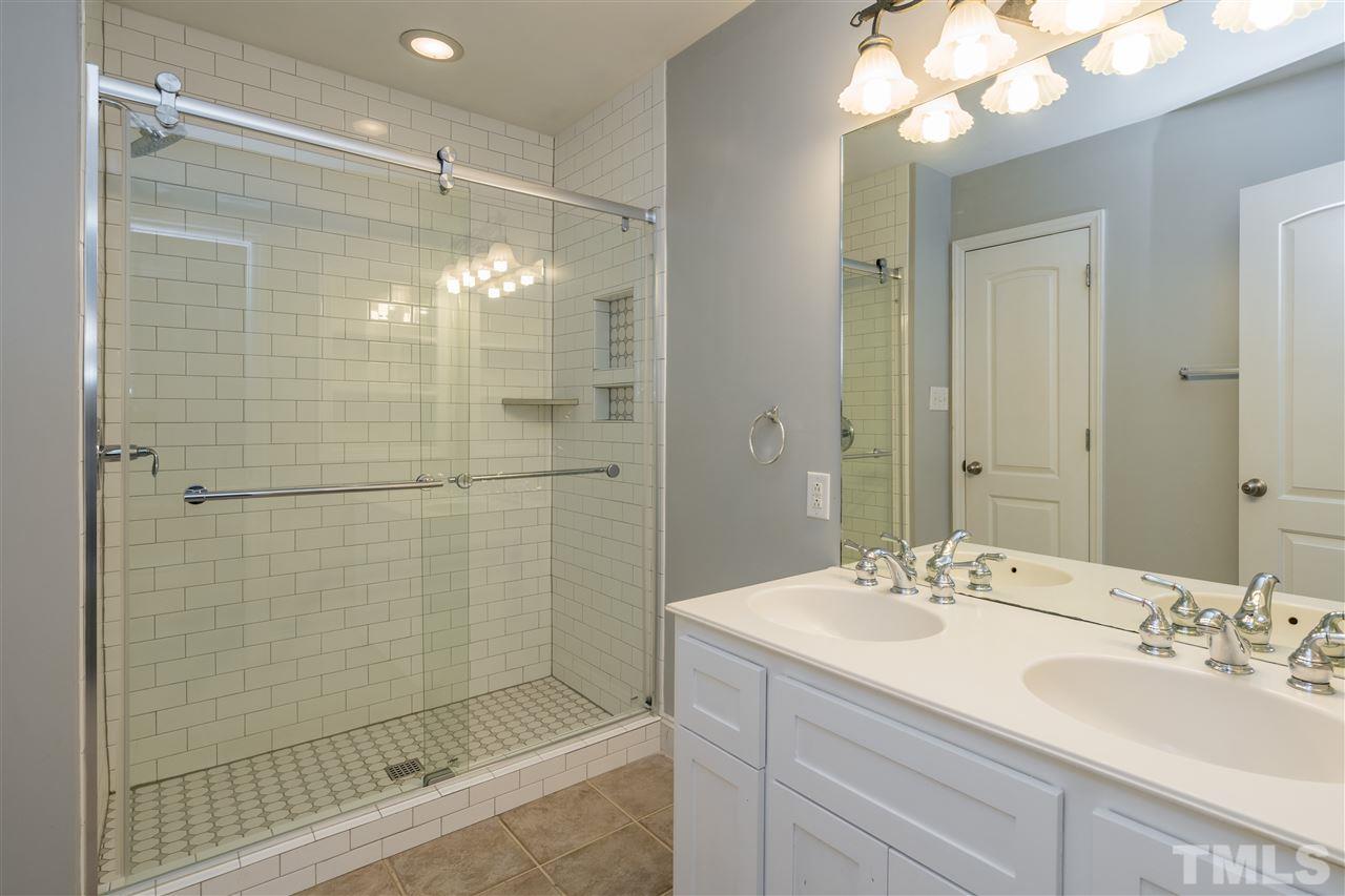 1234 Cross Link Road Raleigh, NC 27610 - Photo 17 of 26 a bathroom with a shower sink and mirror