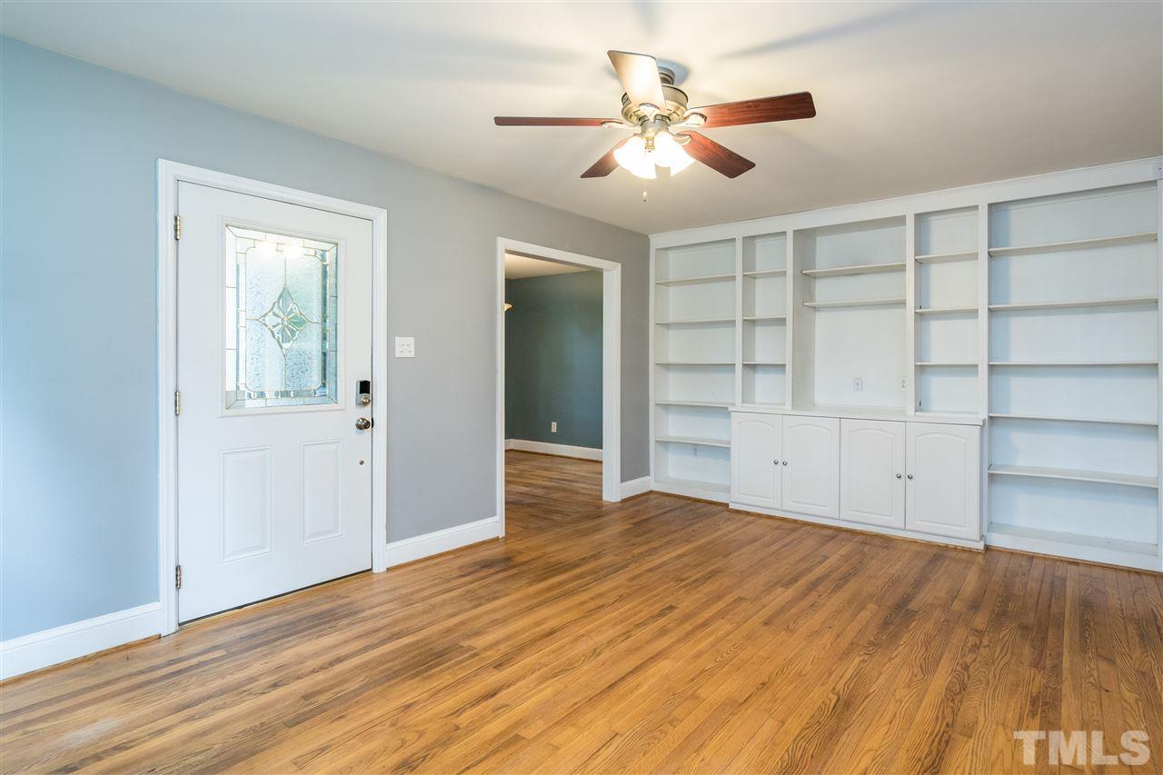 1234 Cross Link Road Raleigh, NC 27610 - Photo 4 of 26 a view of an empty room with a window and wooden floor
