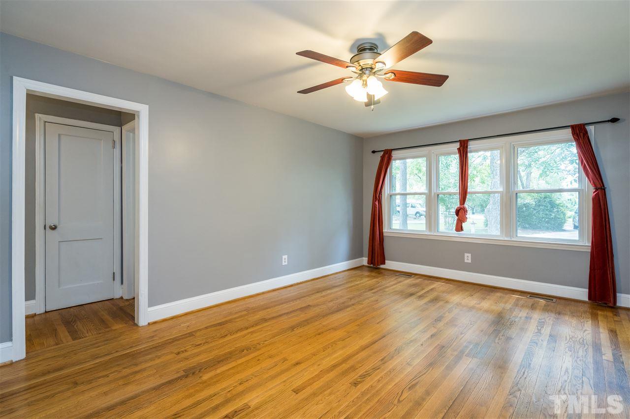 1234 Cross Link Road Raleigh, NC 27610 - Photo 5 of 26 a view of an empty room with wooden floor and a window