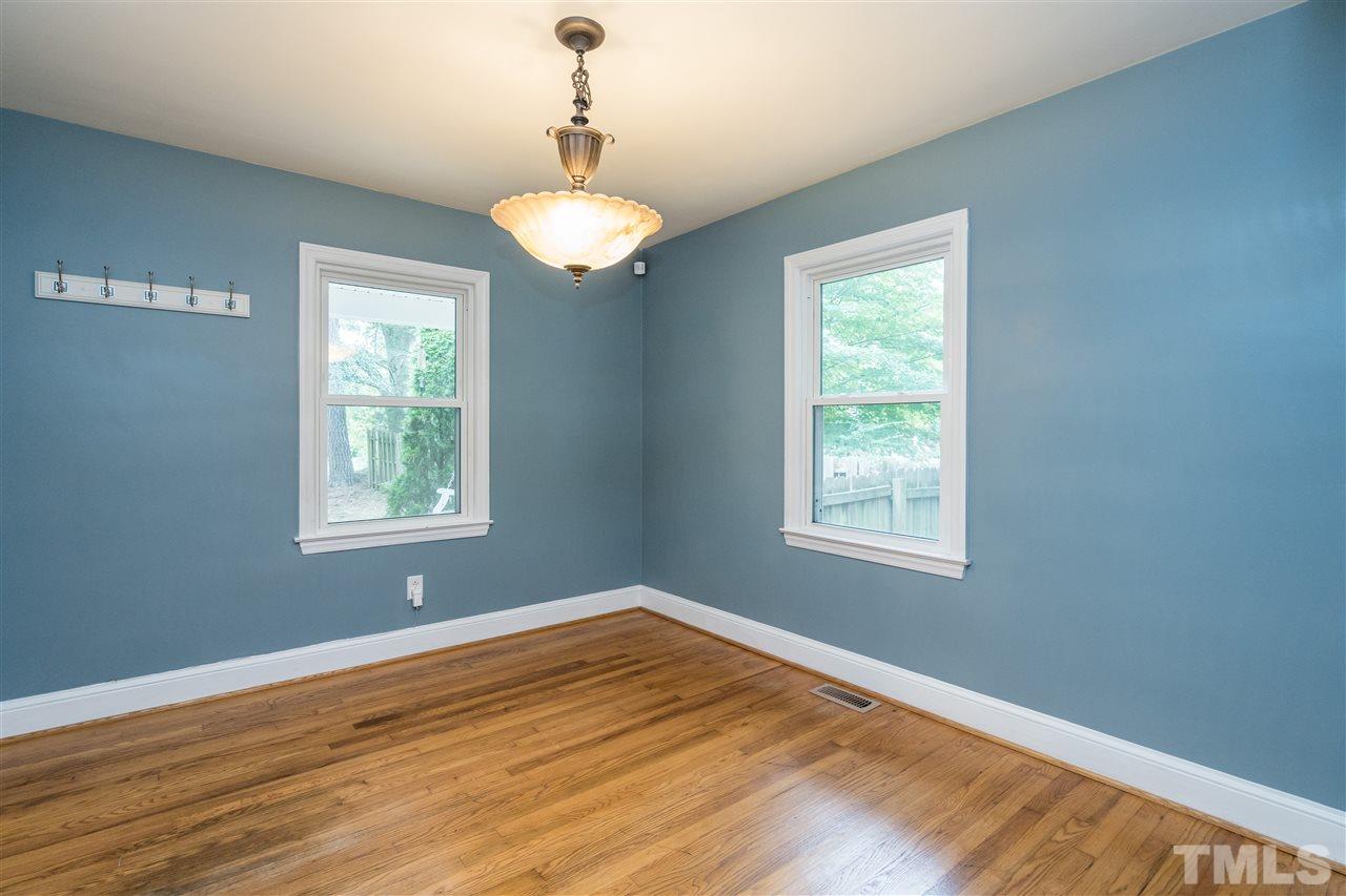 1234 Cross Link Road Raleigh, NC 27610 - Photo 7 of 26 a view of an empty room with wooden floor and a window