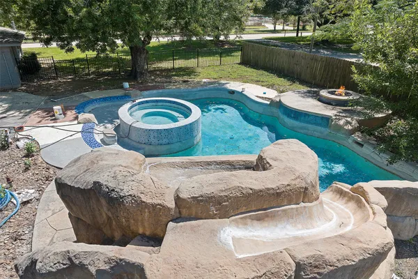 a backyard of a house with yard fountain and outdoor seating