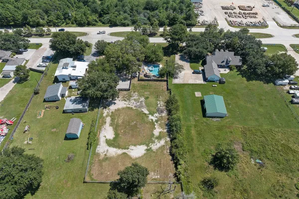 an aerial view of residential houses with outdoor space and trees